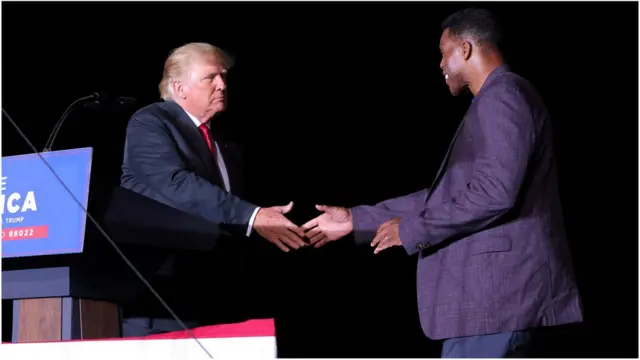 共和党人赫歇尔·沃克（右）与特朗普（左）在2021年9月乔治亚州一次集会上握手。