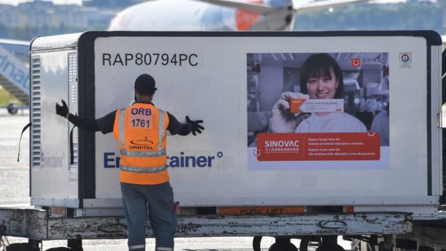 巴西圣保罗瓜鲁柳斯国际机场停机坪上地勤人员卸载刚空运抵达的中国科兴克尔来福疫苗（18/12/2020）
