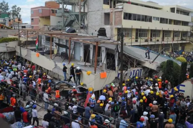 Crowds of volunteers and parents join rescue effort wey dey go on for Enrique Rébsamen elementary school wen collapse for Coapa, South-east of di capital, wey be Mexico City.
