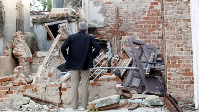 Hombre mira los destrozos en un casa provocados por el tornado.
