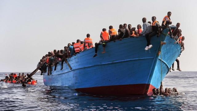Imigrantes em embarcação de madeira