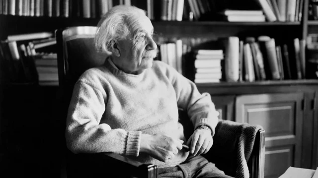 O físico Albert Einstein sentado e olhando para o lado,bet pt eurowinfrente a prateleira com livros