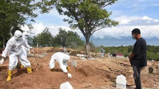 Penggali kubur memakamkan jenazah Covid-19 di pemakaman umum desa Poboya, Kota Palu