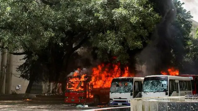 Buses are seen on fire at the Bangabandhu Sheikh Mujib Medical University premises after a clash between students and government supporters during a protest in Dhaka on August 4, 2024