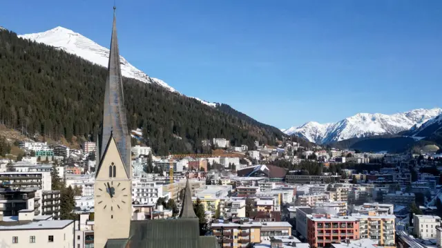 Vista da igreja de São João e da cidade de Davos antes da reunião anual do Fórum Econômico Mundial. Há uma leve camada de neve sobre a cidade e montanhas podem ser vistas ao fundo.