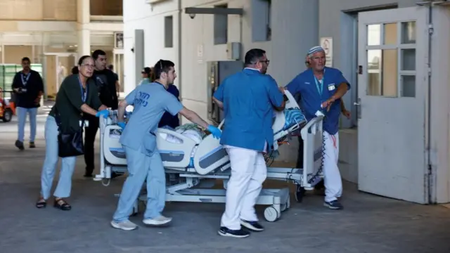 Medical staff transporting a patient on a stretcher at the Soroka Medical Center. 