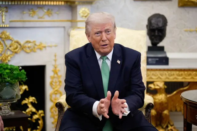 O presidente americano Donald Trump, sentado e falando no Salão Oval da Casa Branca