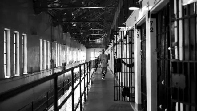 Un détenu marchant dans le couloir d'une prison de la Californie