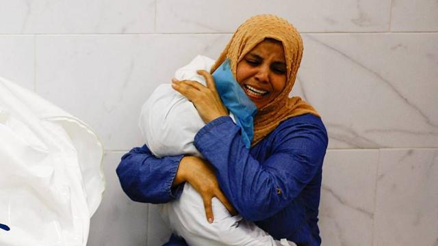 Una madre junto a los restos de su hijo tras el bombardeo a un hospital en Gaza.