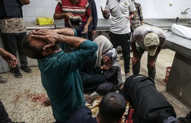 Varias personas desgarradas de dolor por la muerte de un familiar en Gaza.