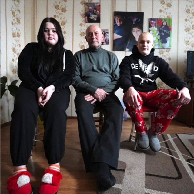 Dima (derecha) y su hermana mayor Daryna (izquierda) ahora están siendo criados por su abuelo Valeriy (centro)