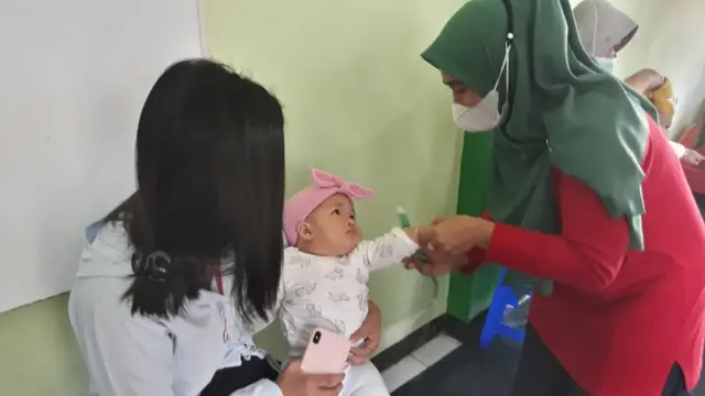 Seorang kader Posyandu di Kelurahan Derwati, Kecamatan Rancasari, Kota Bandung memeriksa seorang balita.