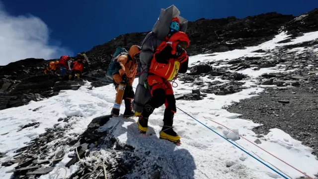 आरोहीको उद्धार गर्दै शेर्पाहरू। 