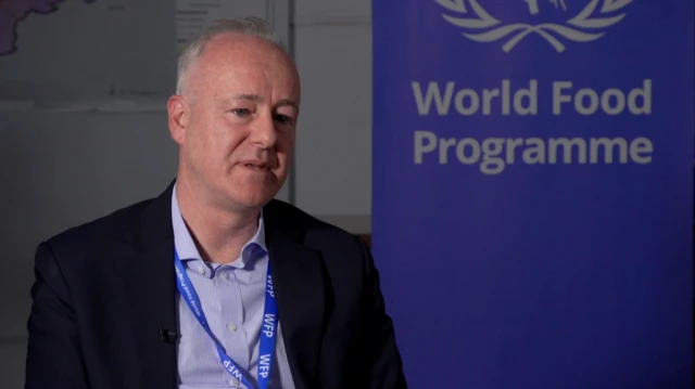 جان آیلیف، نماینده برنامه جهانی غذا در افغانستان، در گفتوگوی اختصاصی با بیبیسی در مقر آن سازمان در کابل افغانستان در کنار نشان این سازمان نشسته است.