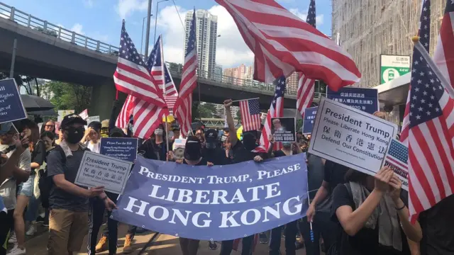 去年香港示威现场多次出现美国国旗，示威者又手持标语希望特朗普可以"解放香港"。