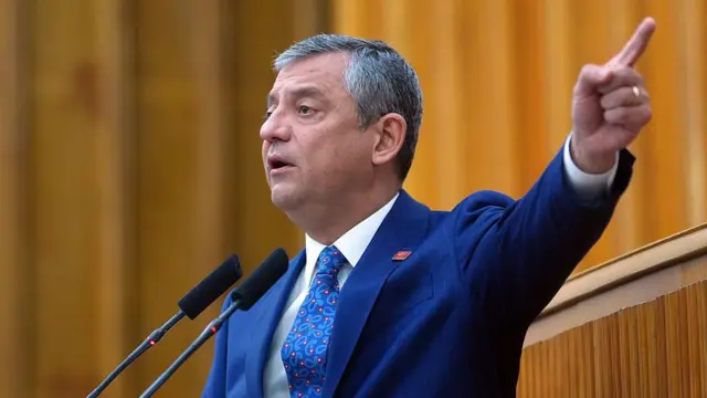 CHP Genel Başkanı Özgür Özel'in 21 Nisan 2026'daki grup konuşması. Üzerinde mavi bir takım elbise var parmağını uzatıp konuşuyor. 