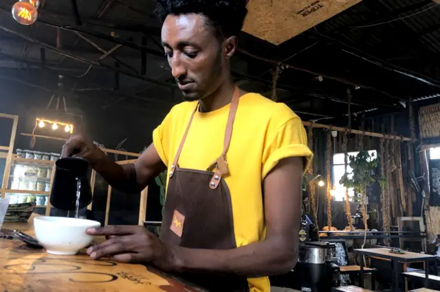 A wani wurin sayar da shayi a Addis Ababa babban birnin Ethiopia, wani mai suna Filimon Tesfaselassie kenan yake zuba shayi cikin kofi.