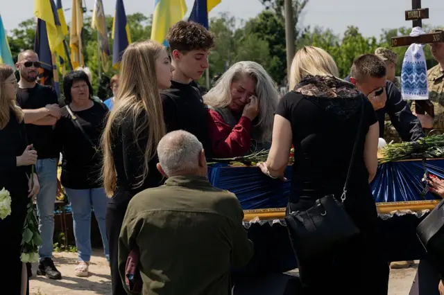 Relatives and friends mourn next to the coffin of 21-year-old Ukrainian serviceman Fedir Epifanov, a fencer callsign "d'Artagnan" who was killed in the battle near the Zaporizhzhia direction, during the funeral ceremony in Kyiv on June 2, 2025, amid the Russian invasion of Ukraine. (Photo by Tetiana DZHAFAROVA / AFP) (Photo by TETIANA DZHAFAROVA/AFP via Getty Images)