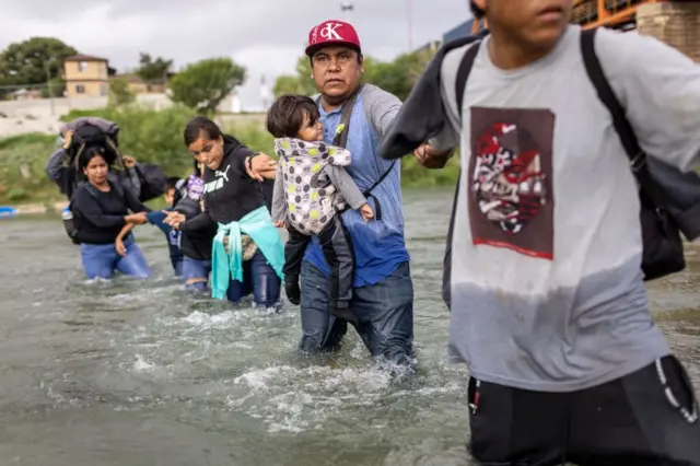 Migrantes cruzando el río Bravo