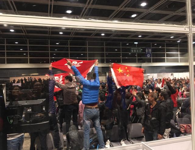 公眾區有人突然歡呼，高舉五星紅旗、支持林鄭月娥的標語。