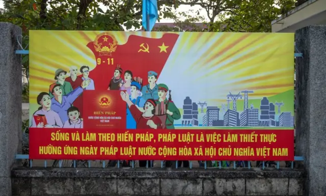 Áp phích tuyên truyền trước cổng một trường trung học ởTây Nguyên nhằm kêu gọi công dân tuân theo pháp luật