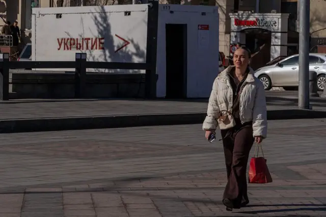 Женщина идет по улице на фоне убежища от обстрелов в Белгороде 