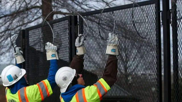 ওয়াশিংটন ডিসির একটি রাস্তা লোহার বেড়া বসিয়ে বন্ধ করে তার ওপর কাঁটাতার লাগানো হচ্ছে, জানুয়ারি ১৮, ২০২১