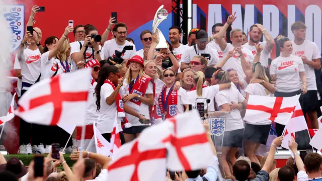 Сборная Англии по футболу среди английских флагов на празднике у Букингемского дворца в Лондоне 29 июля 2025 года после победы на Евро