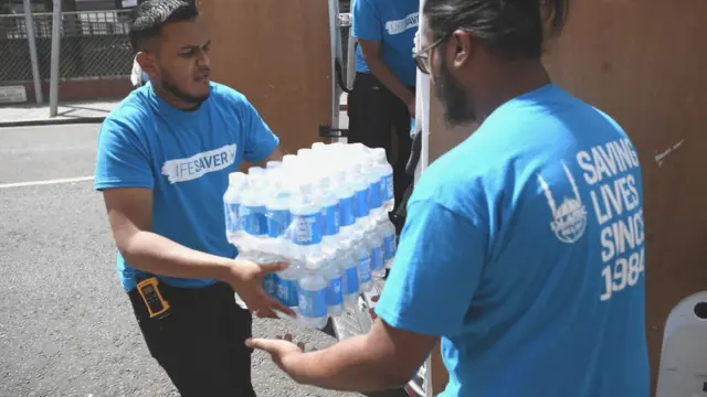 પાણીની બોટલની હેરફેર કરી રહેલા લોકોની તસવીર