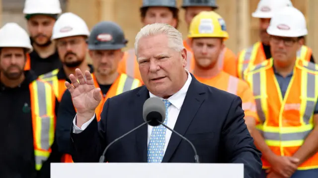 O primeiro-ministro de Ontário, Doug Ford, discursa para trabalhadores com roupas de segurança ao fundo