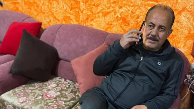Suheil al-Talooli, talking on a phone while sitting on a sofa in a photo taken before the 31 October attack