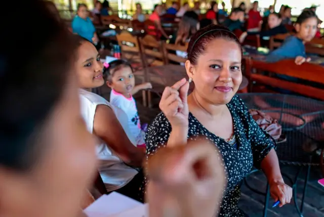 Mujer utiliza el lenguaje de signos en el Café de las Sonrisas en Nicaragua.