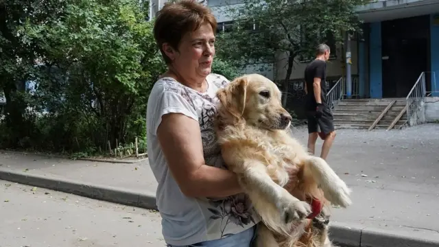 امرأة تحمل كلبها