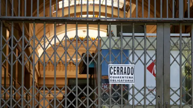 Rejas en un comercio en Argentina con una placa que dice "Cerrado, cuarentena obligatoria"