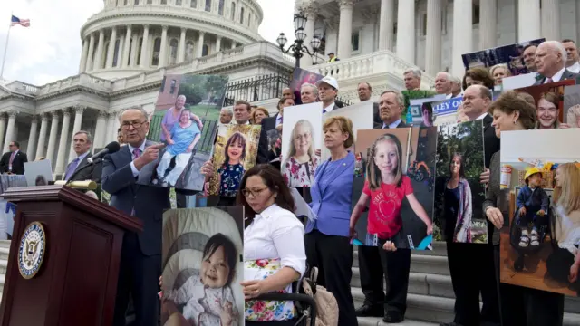 US Senate Democrats hold photos of people who would lose their health coverage under the Republican healthcare bill, during a press conference at the US Capitol on 27 June 2017