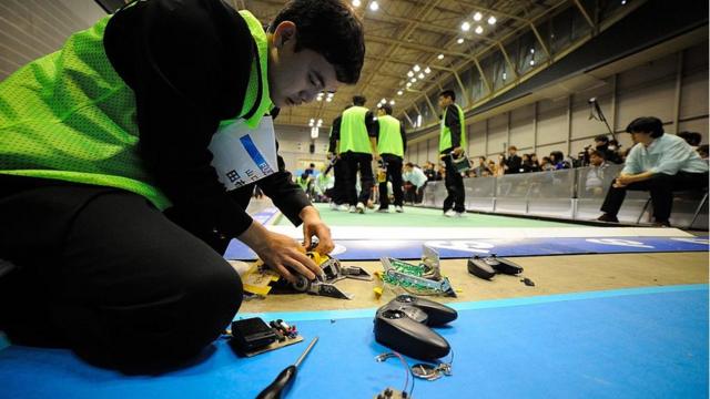 Jovens no Japão mexendo em aparelhos eletronicos