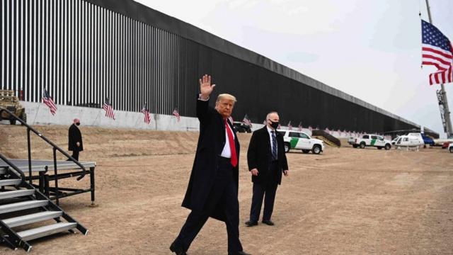 US President Donald Trump waves after speaking and touring a section of the border wall in Alamo, Texas on 12 January 2021