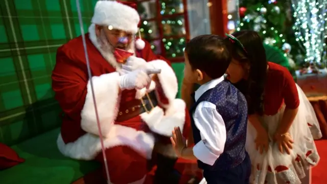 Crianças falando com Papai Noel atravéssolar nova slotvidro