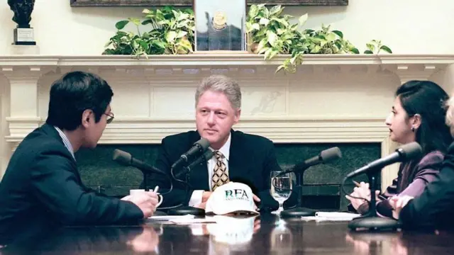Tổng thống Mỹ Bill Clinton (giữa) được phỏng vấn bởi hai phóng viên Feng Xiao Ming (trái) và Arin Basu (phải) từ Đài Á Châu Tự Do vào ngày 24/6 tại Nhà Trắng ở Washington DC. Ông ngồi tại một bàn, với hai phóng viên ở hai bên.