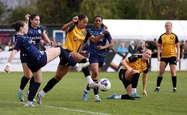 Бреон Грант из «Реал Бедфорд» и Сара Робертс из «Лондон Сивард» борются за мяч во время матча Женской национальной лиги Англии.