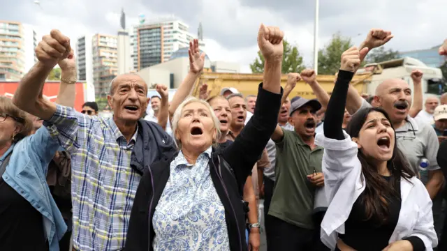 Yumrukları havada slogan atan partililer