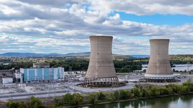 Dos enormes torres de refrigeración se alzan en Three Mile Island, a la izquierda se ve la central eléctrica azul y blanca.