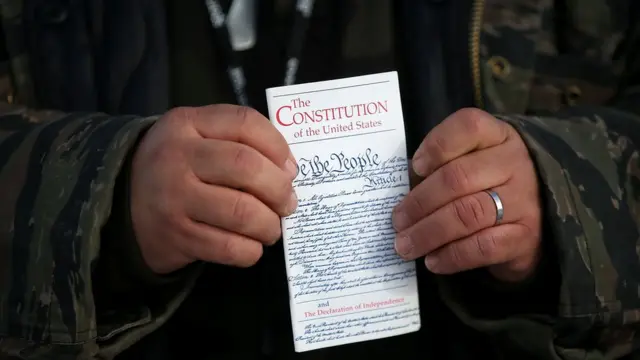 Hombre sosteniendo la Constitución de EE.UU.