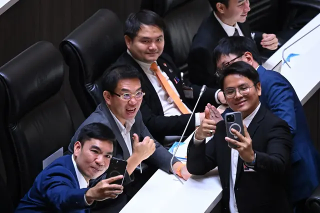 วิโรจน์ ลักขณาอดิศร ถ่ายรูปกับเพื่อน สส. หลังเสร็จสิ้นการอภิปรายที่ใช้เวลาราว 70 นาที ท่ามกลางการประท้วงเป็นระยะของ สส.เพื่อไทย