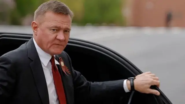 ரஷ்ய முன்னாள் போக்குவரத்து அமைச்சர் ரோமன் ஸ்டாரோவோய்ட் காரின் கதவை பிடித்துக்கொண்டு