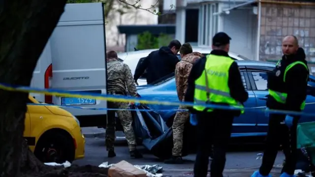 Поліцейські стоять поряд з тілом загиблого