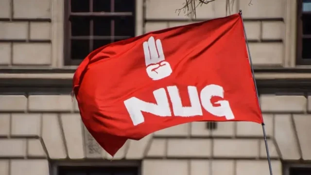 NUG စာလုံး ရေးထိုးထားပြီး လက်သုံးချောင်းထောင်ထားတဲ့ ပုံဖော်ရေးဆွဲထားတဲ့ အလံတစ်ခု (ပုံဟောင်း)