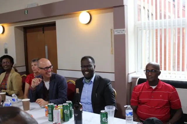 Abantu bicaye barimo gutwenga, imbere yabo hari amacupa