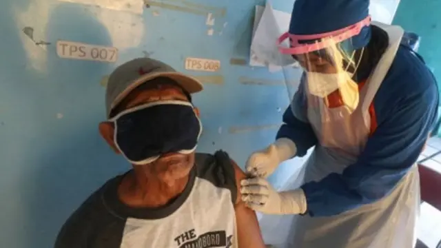 Petugas kesehatan menyuntikkan vaksin COVID-19 kepada ketua RT di Kota Kediri, Jawa Timur, Rabu (17/03).