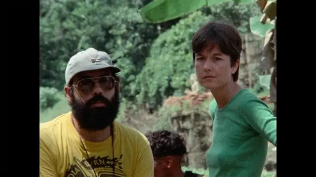 Бородатый мужчина в кепке и солнечных очках и темноволосая женщина с короткой стрижкой.